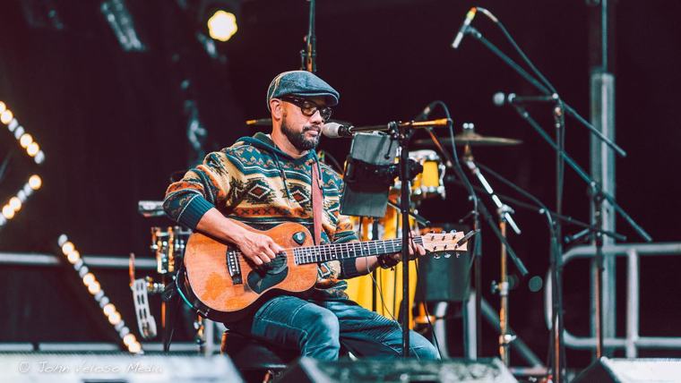 Musician on stage with an acoustic guitar